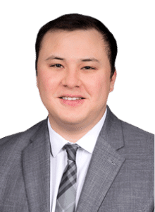 Professional headshot of a man in a gray suit with a striped tie, smiling.