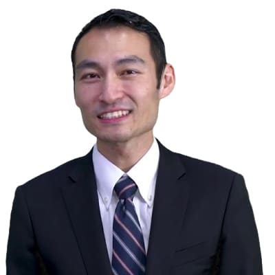 Smiling man in a dark suit and striped tie, posed against a white background (professional portrait).