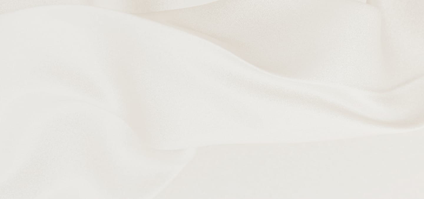 Soft white fabric with gentle folds and smooth texture across the surface.