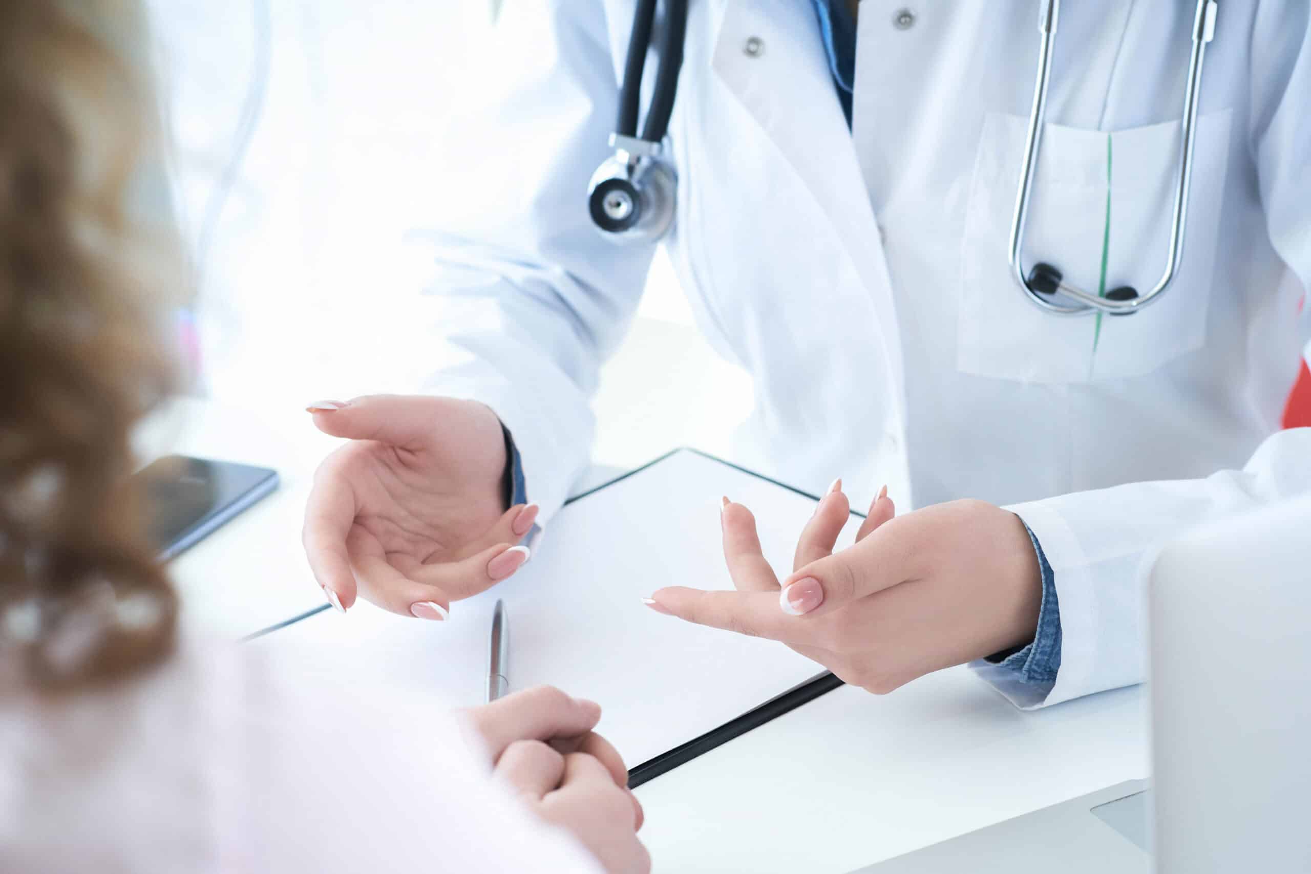 Patient listening intently to a female doctor explaining patient symptoms or asking a question as they discuss together in a consultation. Physician examining patient.