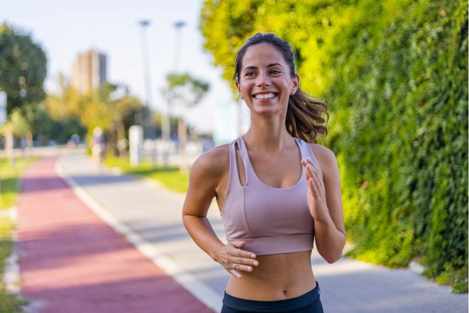 A woman running on an outdoor running path.