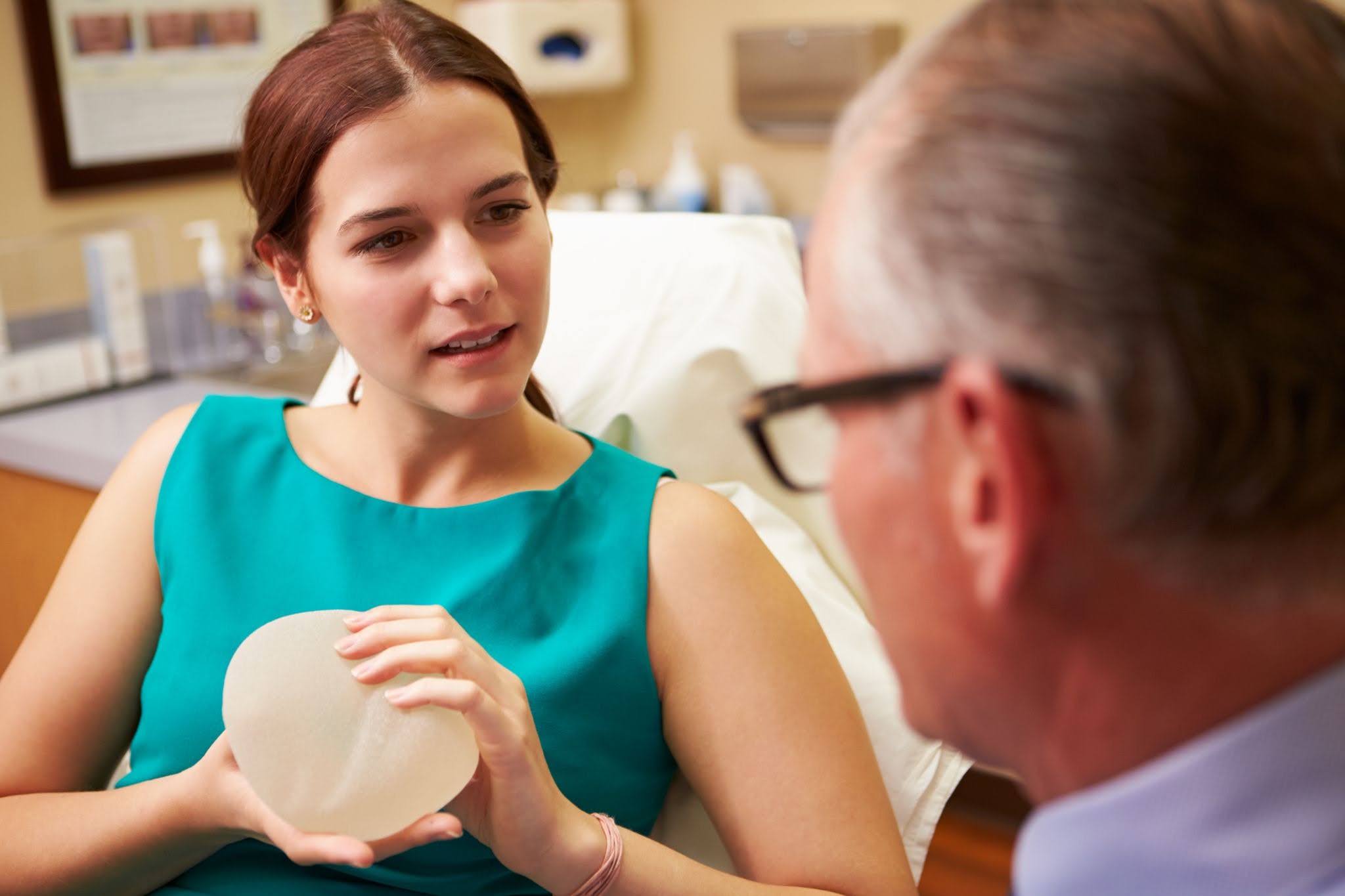 woman holding implant in doctors office