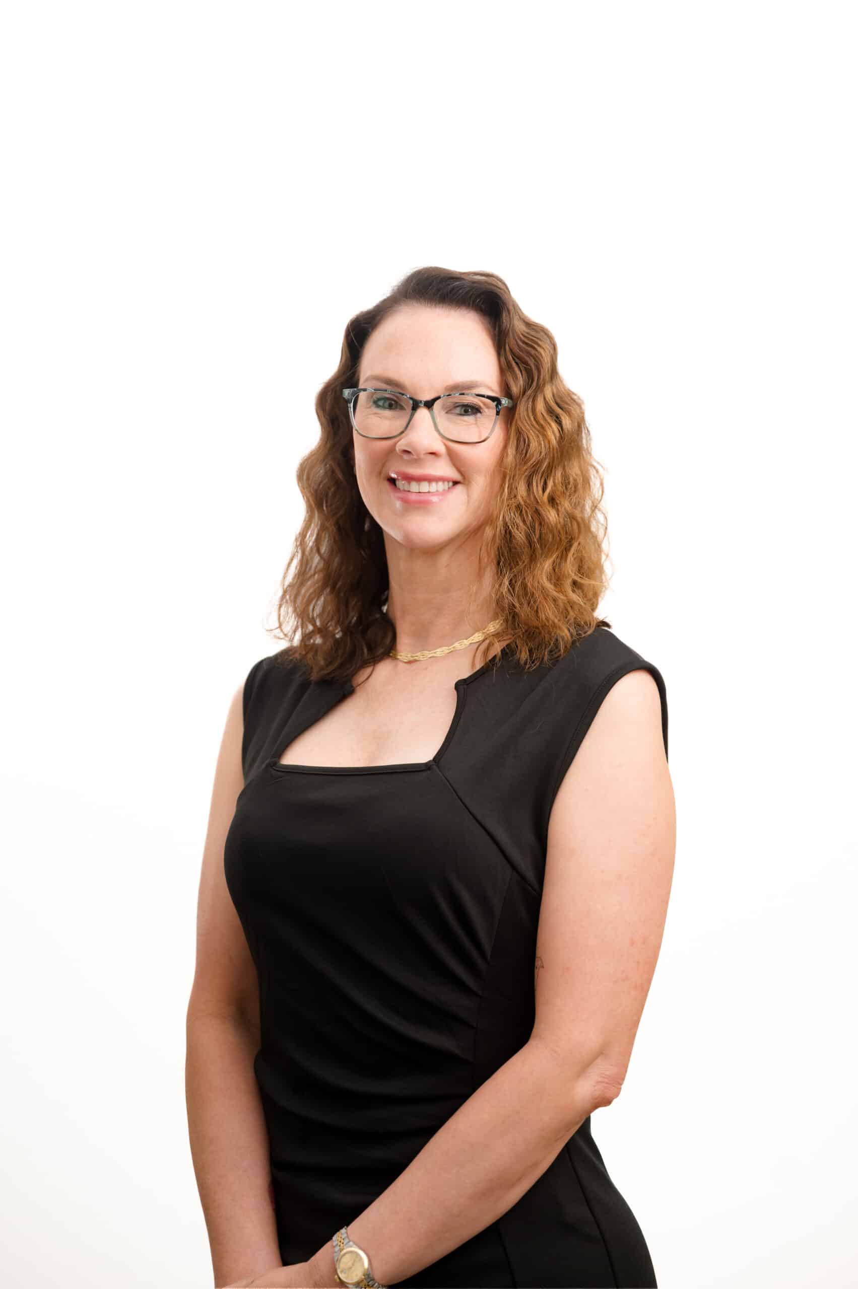 Professional woman, smiling, wearing a black dress against a white background.