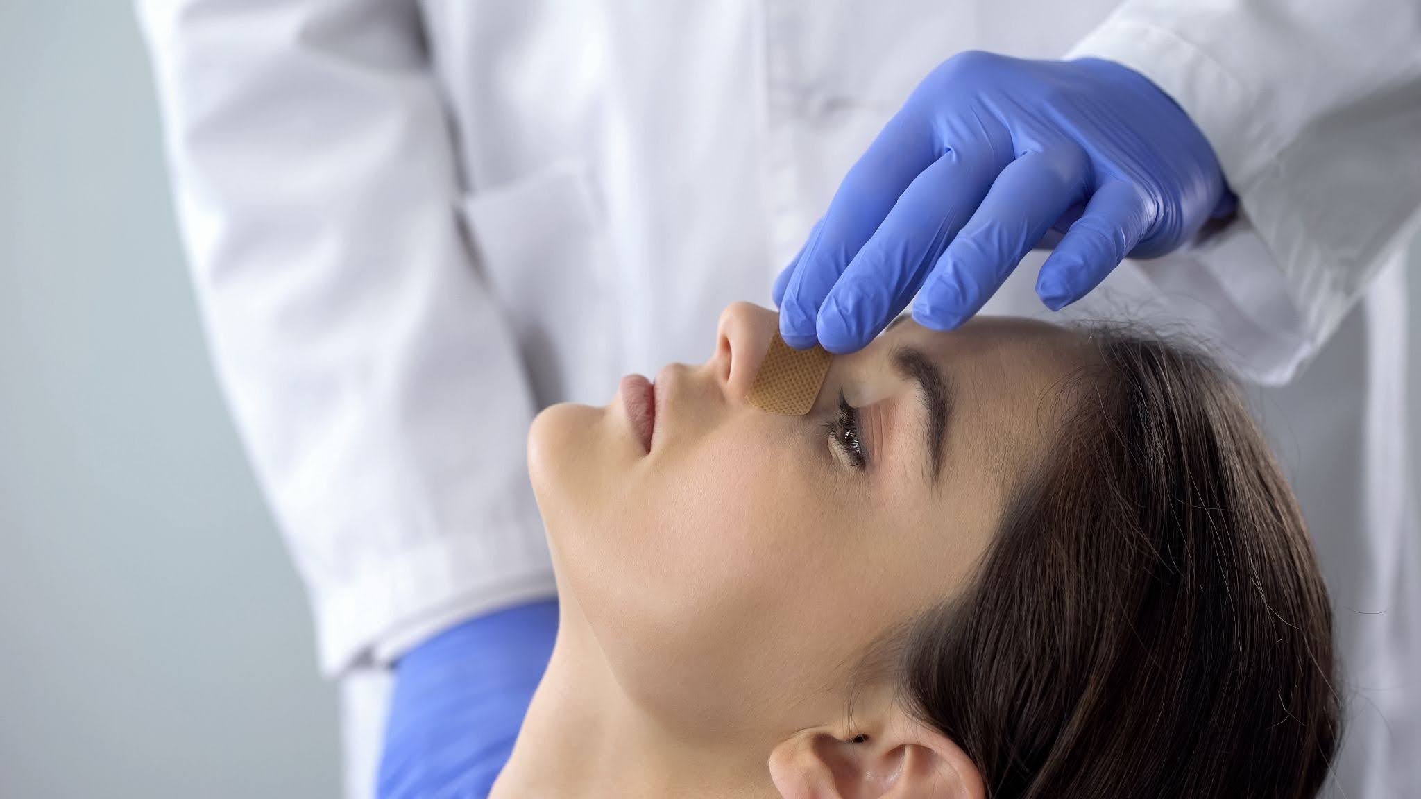 Doctor touching the bridge of a woman's nose
